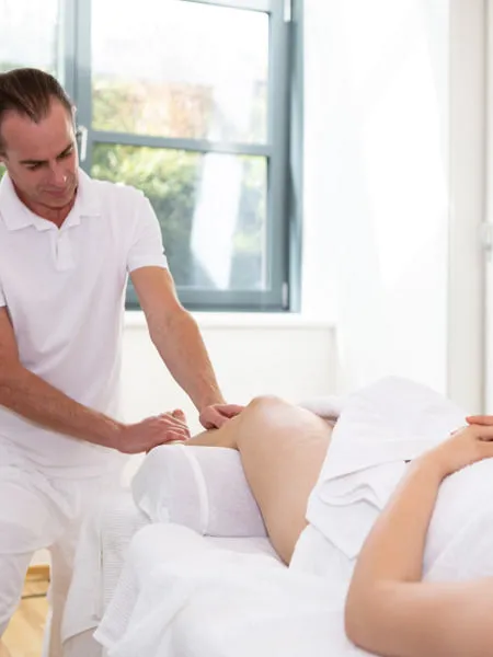 René Kricker behandelt den Rücken einer Patientin auf der Massageliege