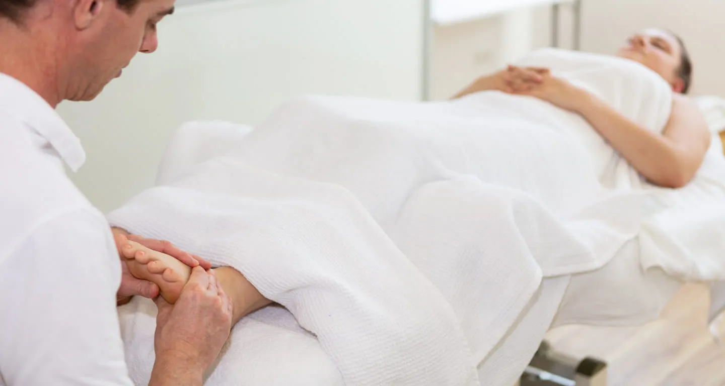 Behandlung von Unterschenkel und Achillessehne auf der Therapieliege